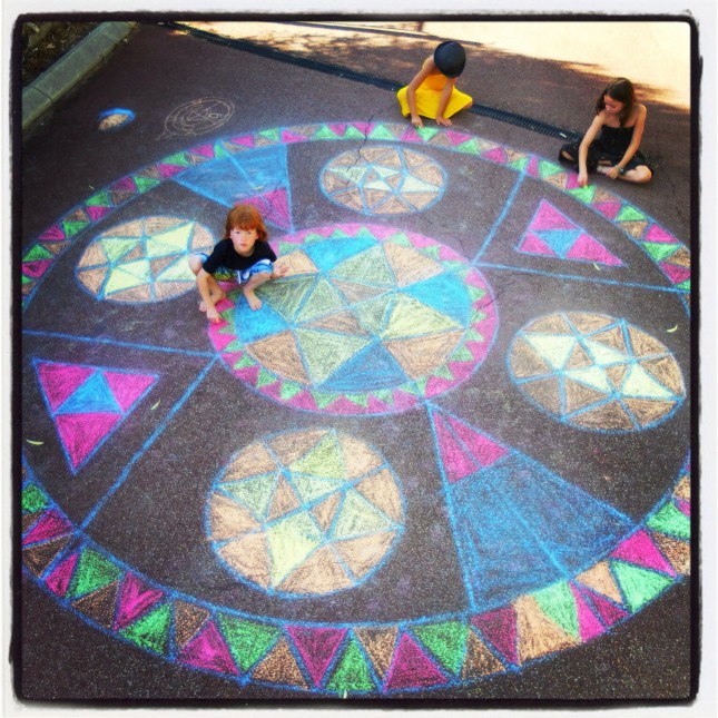 High shot of a Rainbow Mandala drawn in chalk on the driveway